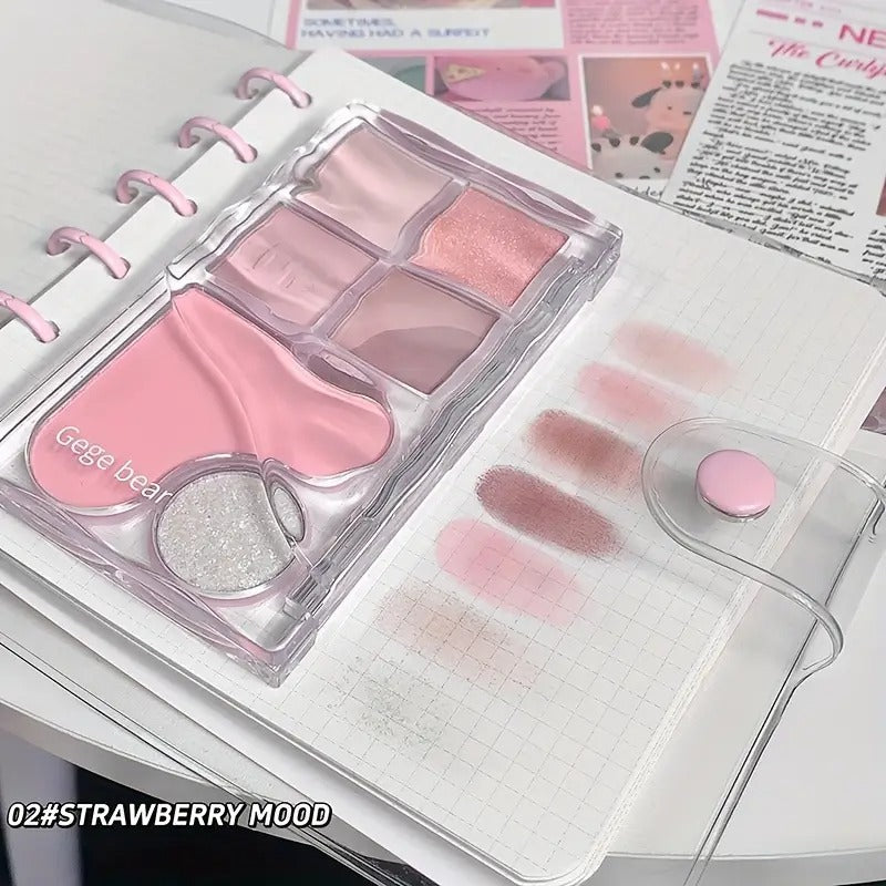 gege bear matte eyeshadow palette in pink pigmenation and all 7 swatches are showin on a white matte paper of a book 
