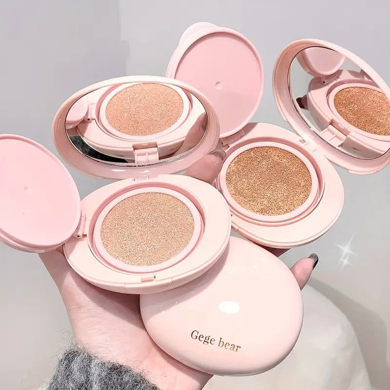 two pieces of air cushion foundation 'Gege bear' branding held by a hand against a light gray background