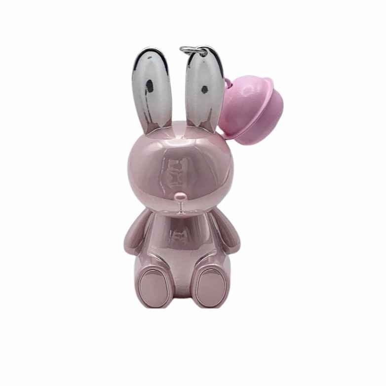 Pink rabbit-shaped lipsticks with a bell on a white background