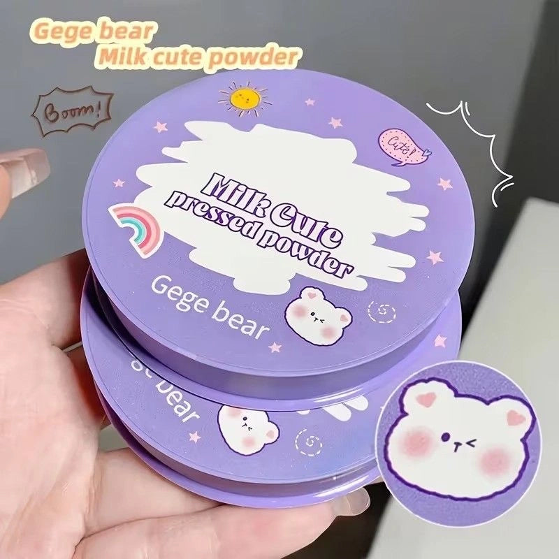 Purple compact powder case with cartoon bear design held by a hand