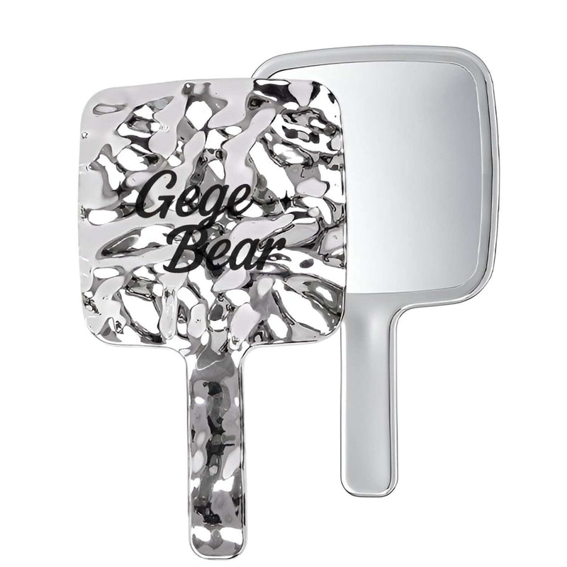 Handheld mirror with decorative handle and 'Gege Bear' text on a white background