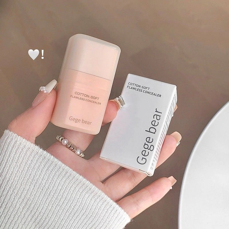 Hand holding a Gege bear concealer and its packaging against a neutral background