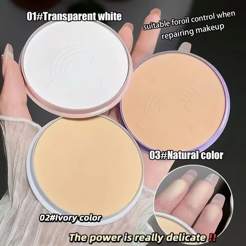 Three makeup compact powders in different colors held by a hand.
