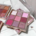 pink glittery eyeshadow palette stacked on its packagin on a white table 
