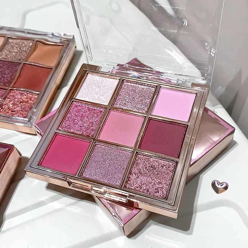 pink glittery eyeshadow palette stacked on its packagin on a white table 