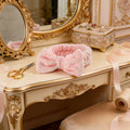 a pink headband on a luxury vanity table showing class with props like ribbon and sissors 