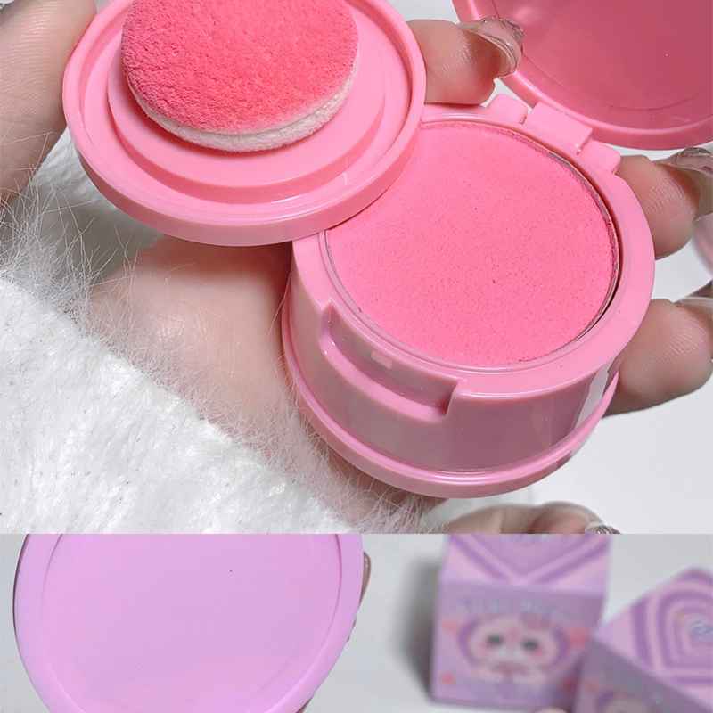 pink powder blush dabbed by the puff showing pigmentation on a hand of a model 