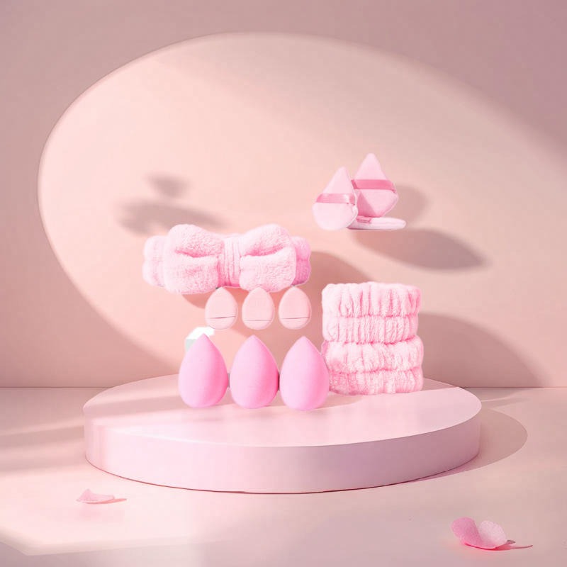 Set of pink beauty tools on a pink platform with a soft pink background