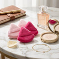 four baby pinka and hot setting powder sponge on a table with props