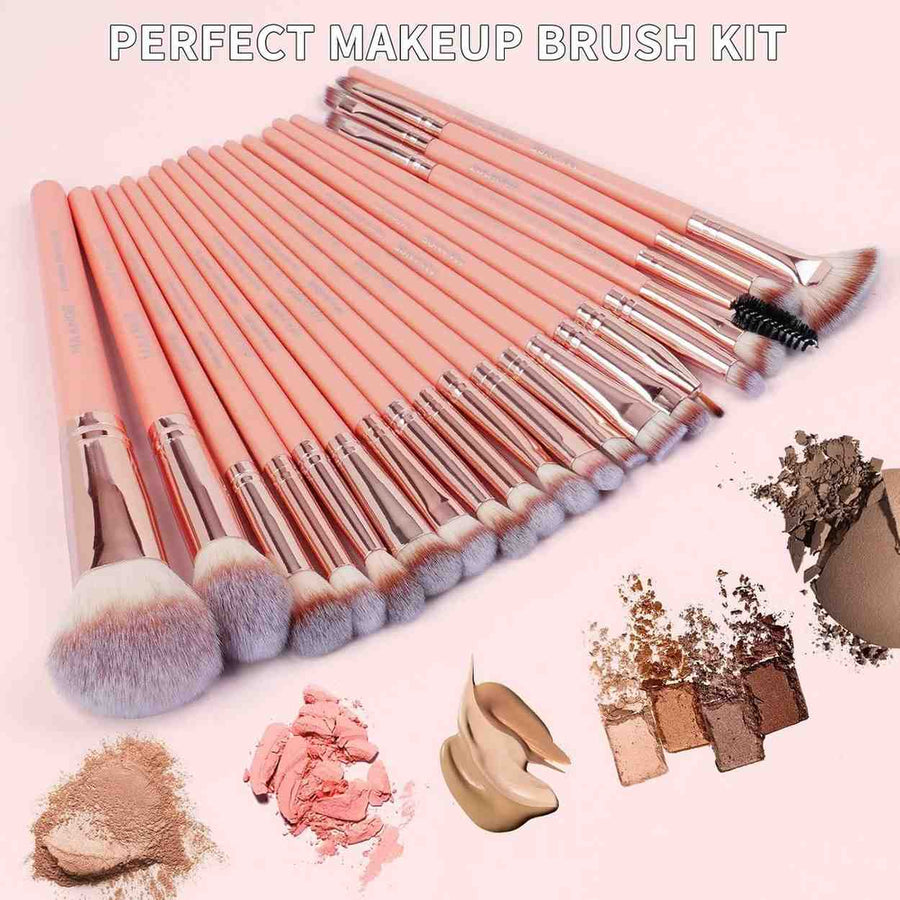 Makeup brush set with pink handles and silver ferrules on a pink background, surrounded by makeup products.