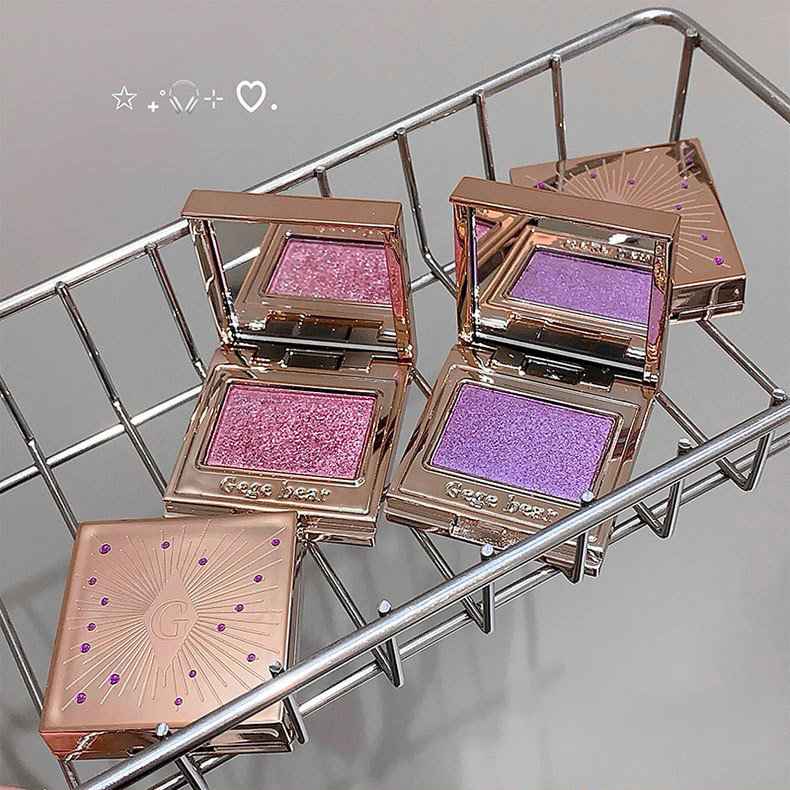 eyeshadow shimmer with pink and purple shades on a metal surface