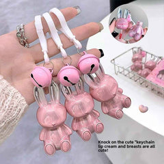 Pink bunny-shaped keychain lip stick held by a hand with a blurred background