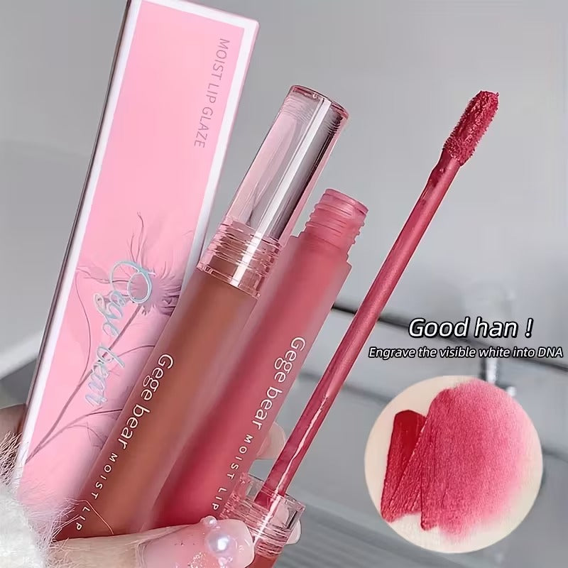 Pink lipstick with applicator and packaging on a gray background