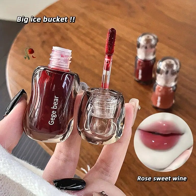 red lip glosses set with 'Geege bear' branding on a wooden table.