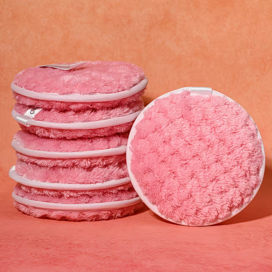 Stack of pink reusable makeup pads with a close-up on a peach background