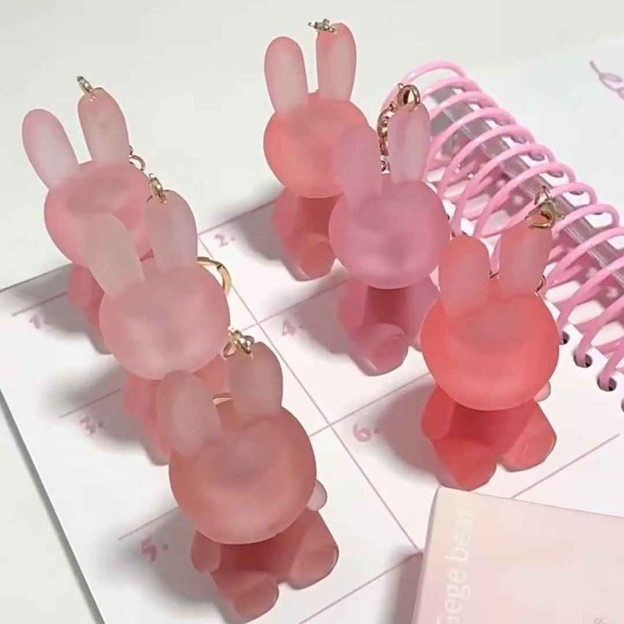 Pink rabbit-shaped lipsticks on a white surface