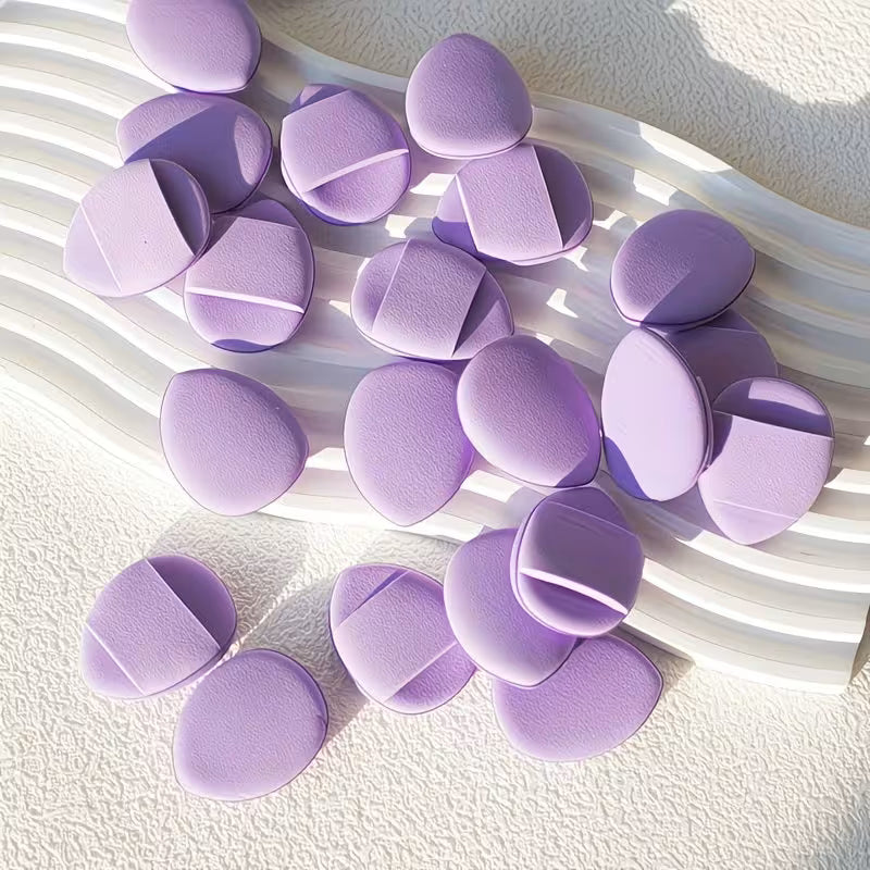 Purple makeup sponges on a textured white surface