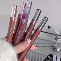 Four lipstick held by a hand with a blurred background