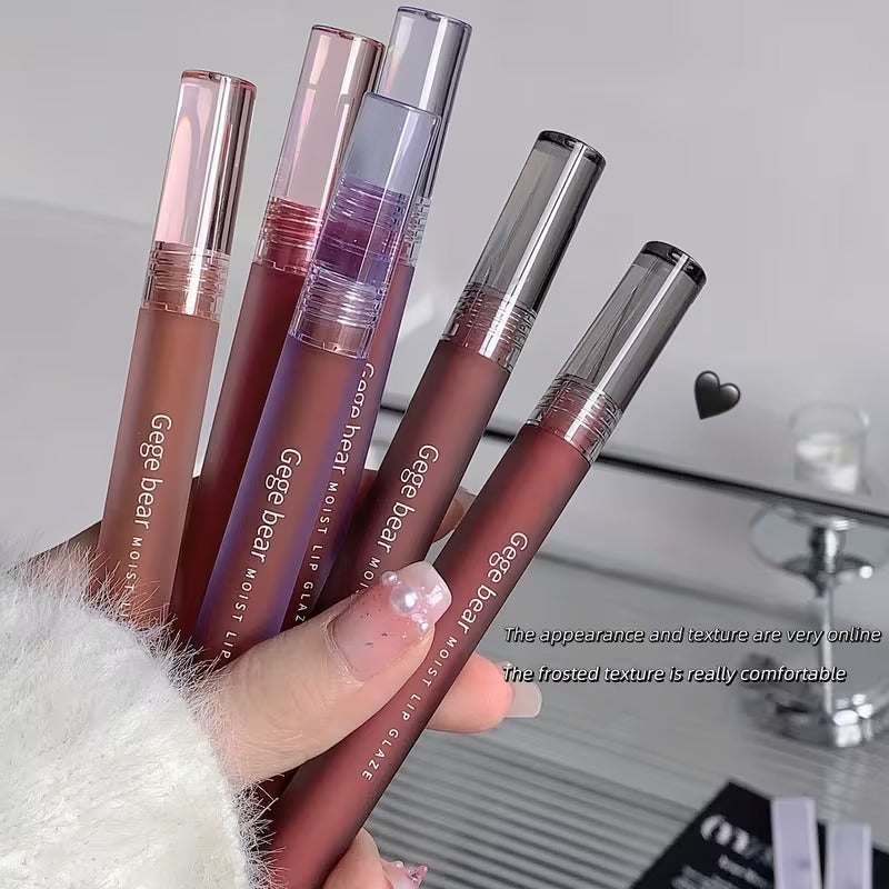 Four lipstick held by a hand with a blurred background