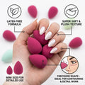 Hand holding pink mini makeup sponges with features highlighted on a white background
