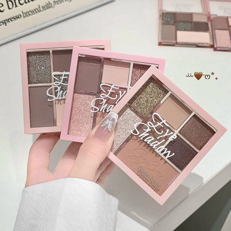 Eyeshadow palettes with 'Eye Shadow' text held by a hand on a light background