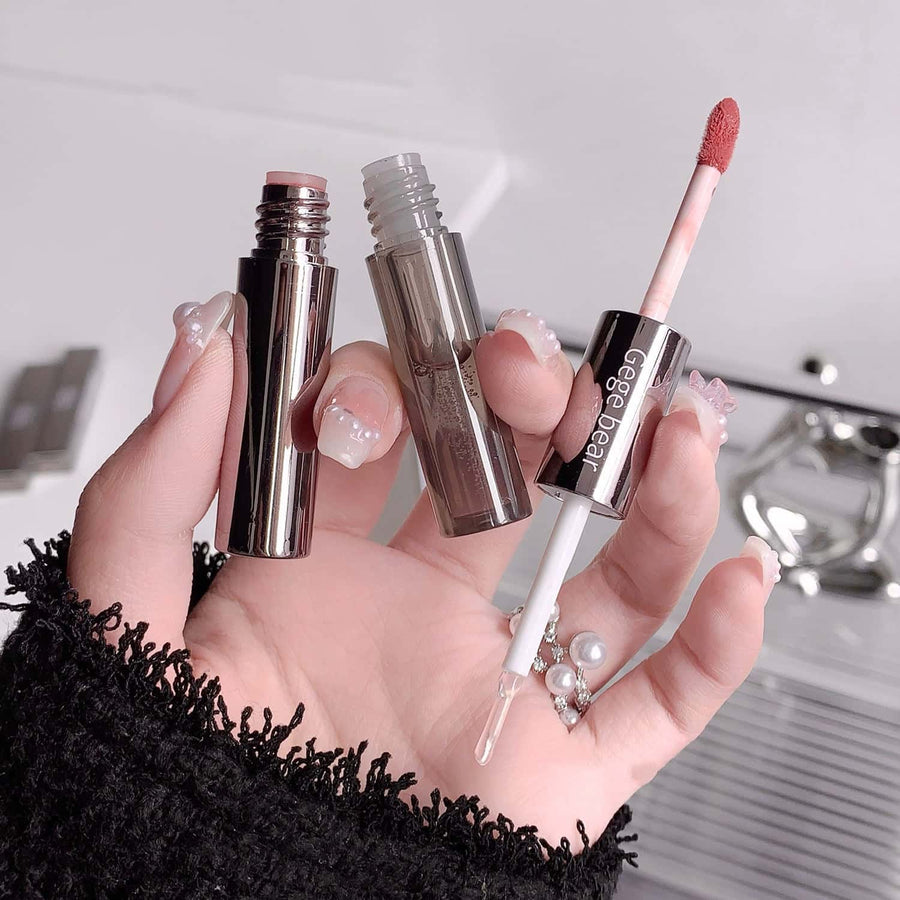 Hand holding lip gloss with visible gege bear branding against a neutral background