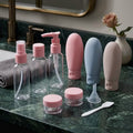 travel bottles, tubes and container with spatula and funnel on a green slate in a bathroom setting 