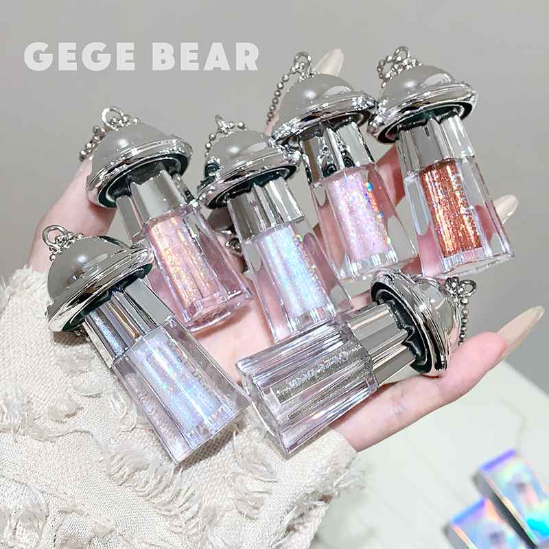  6 different shades of liquid shimmer eyeshadow held on a hand of a lady against the grey background 