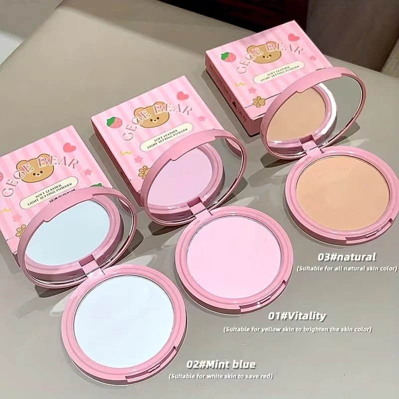 Pink makeup compact powder with open cases on a light surface with 'gege bear' printed on the top. 